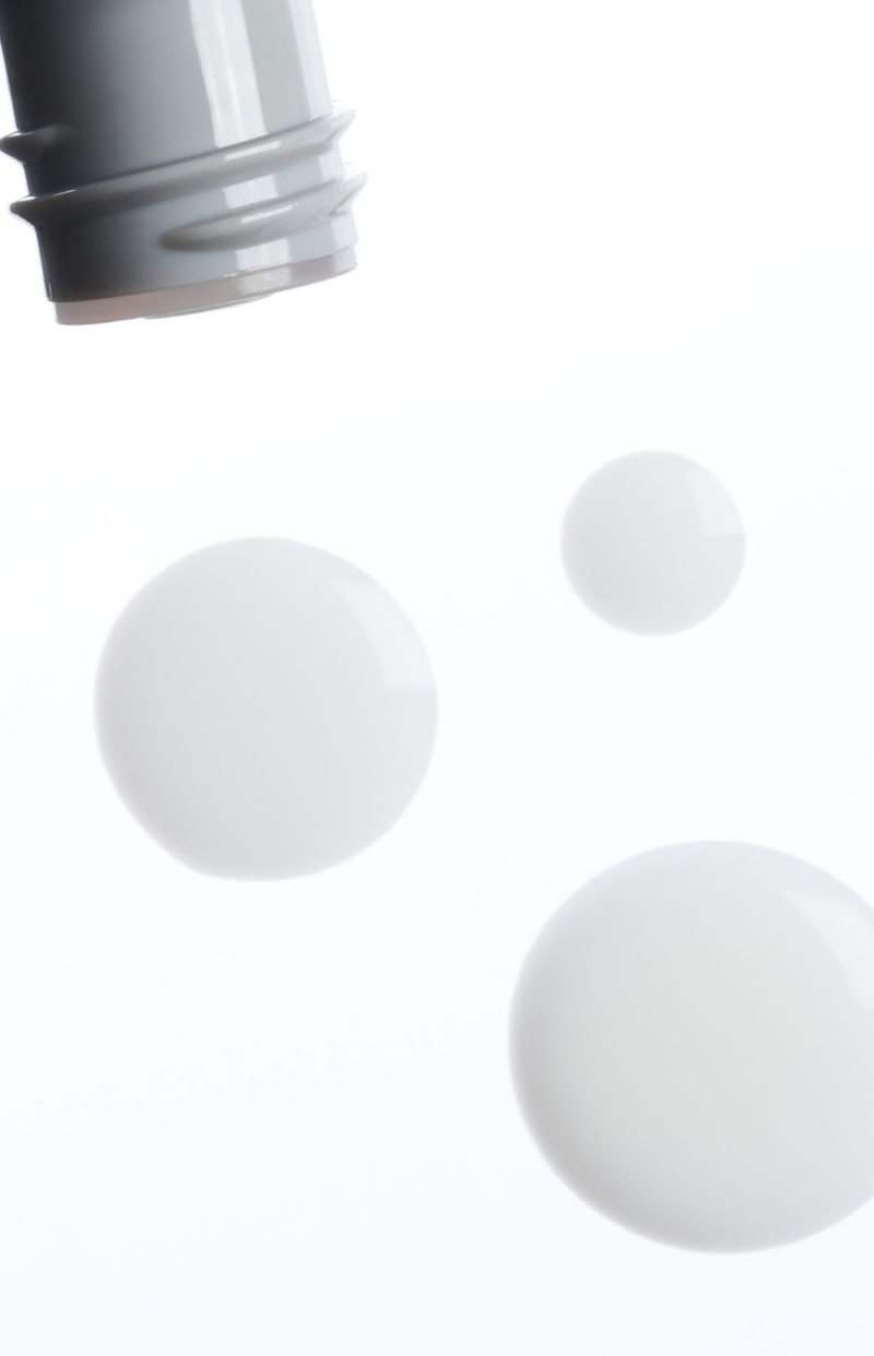 Drops of serum beside an open bottle